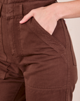 Short Sleeve Jumpsuit in Fudgesicle Brown front pocket close up. Alex has her hand in the pocket.