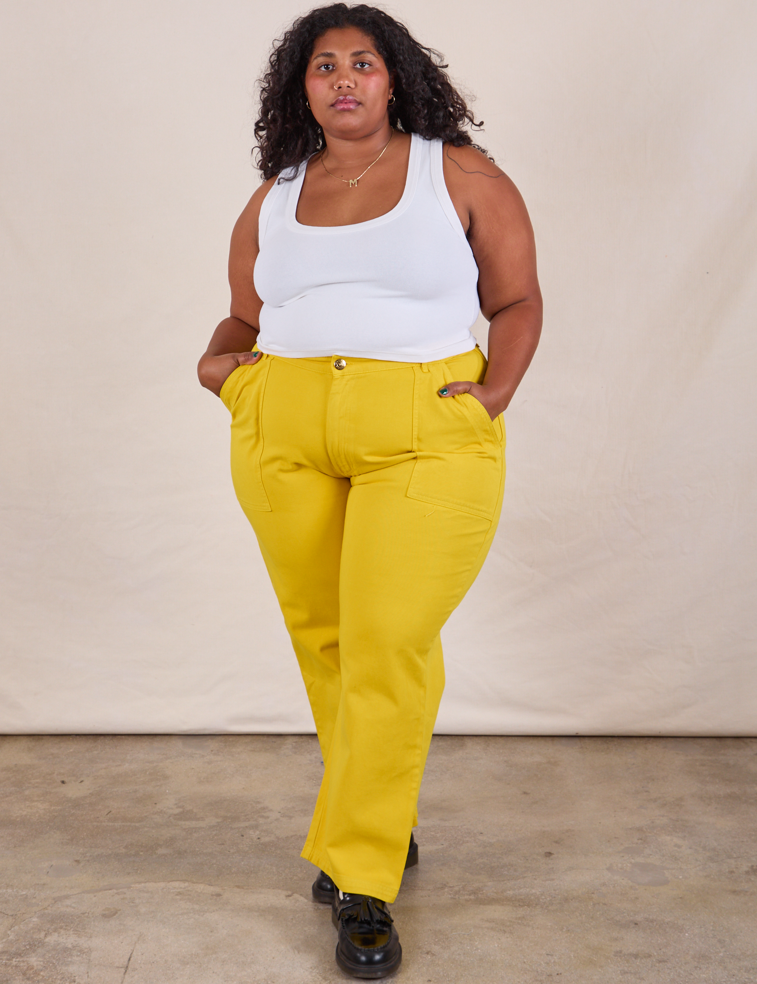 Morgan is 5&#39;5&quot; and wearing 2XLWork Pants in Golden Yellow paired with a Cropped Tank in Vintage Tee Off-White