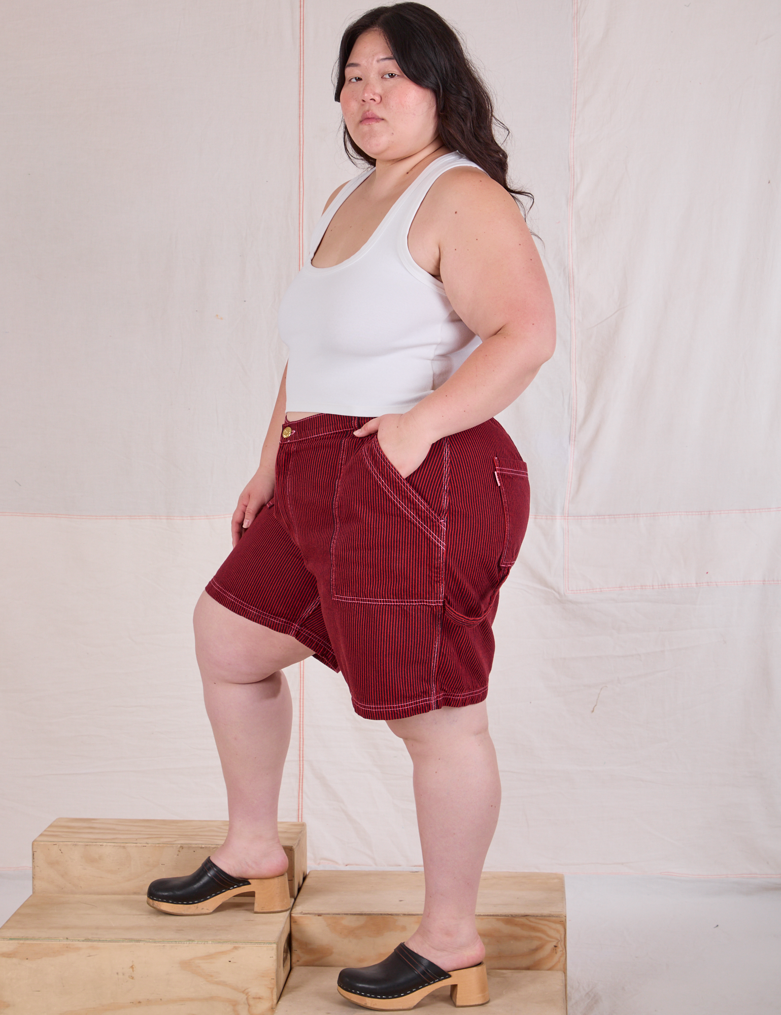 Side view of Railroad Carpenter Shorts in Mustang Red and Cropped Tank in Vintage Tee Off-White on Ashley