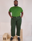 Elijah is 6'3" and wearing 1XL Mid-Rise Work Pants in Swamp Green paired with a lawn green Organic Vintage Tee