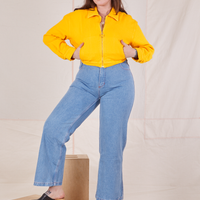 Sydney is 5'9" and wearing XS Ricky Jacket in Sunshine Yellow with both hands in the pockets