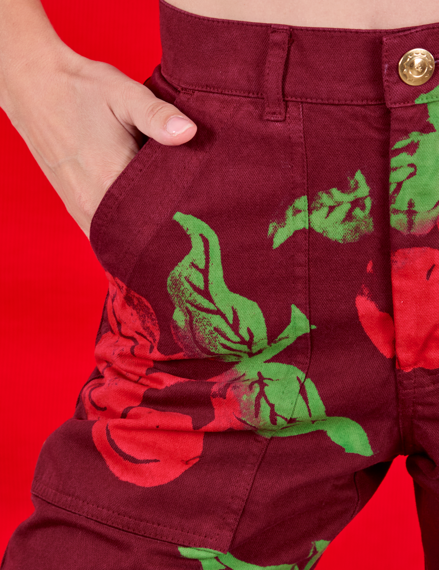 Close up of Madeline&#39;s hand in the front pocket of Paintstamped Work Pants in Cherry