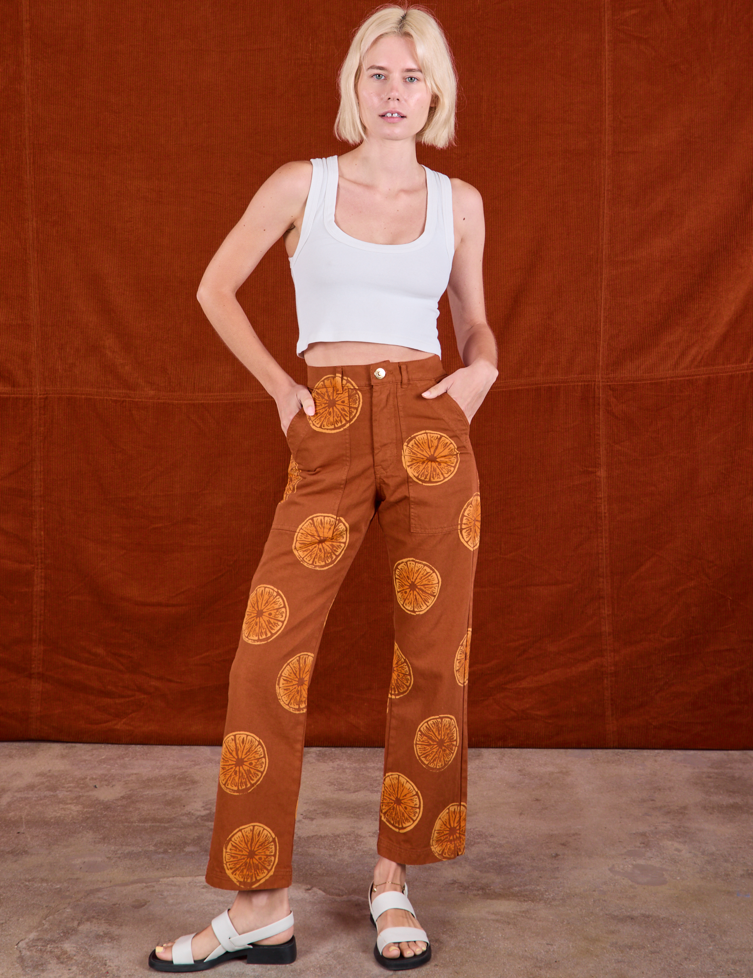 Madeline is 5&#39;9&quot; and wearing XXS Paintstamped Work Pants in Orange paired with a Cropped Tank in vintage tee off-white