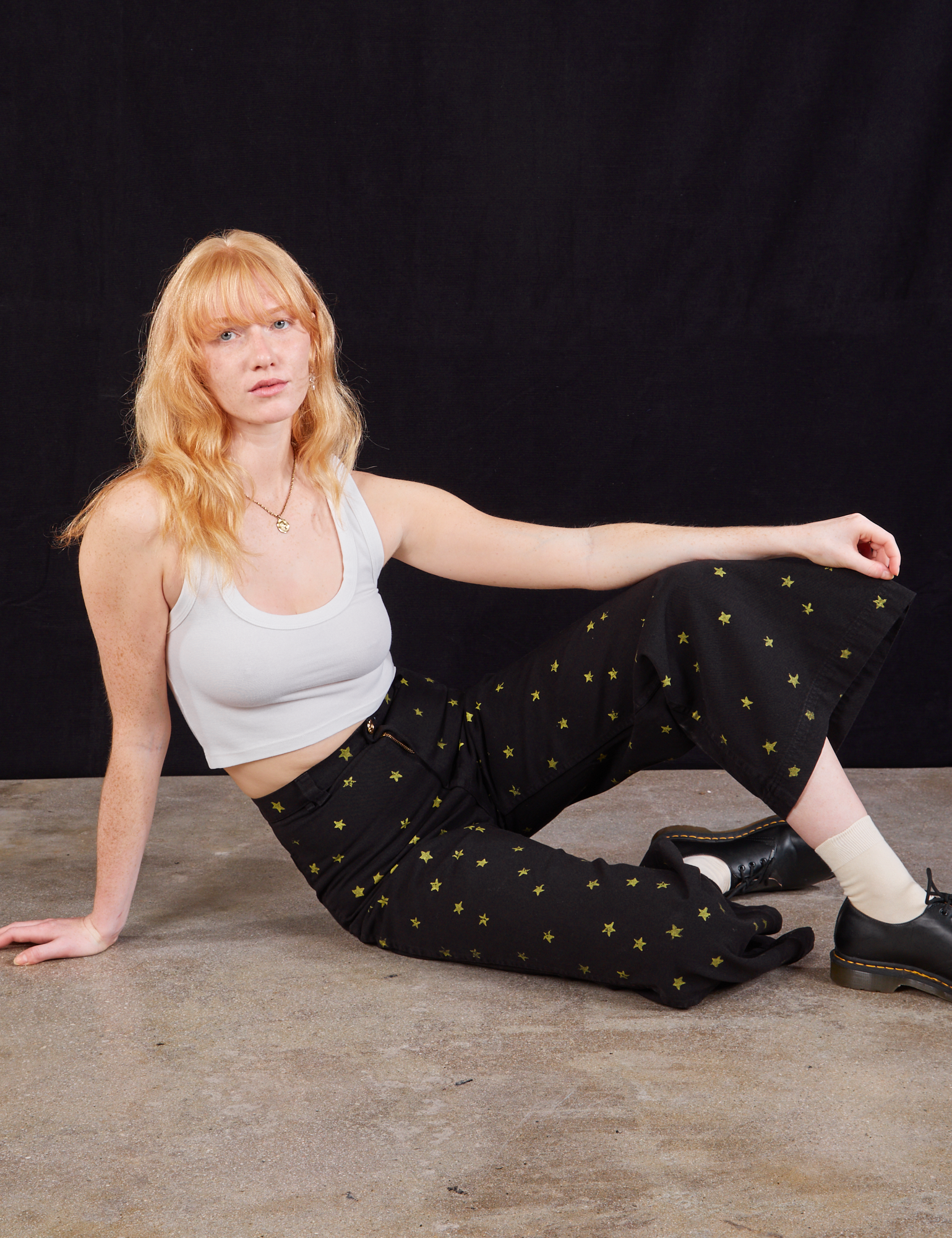 Margaret is wearing Star Bell Bottoms in Black and a Cropped Tank in vintage tee off-white