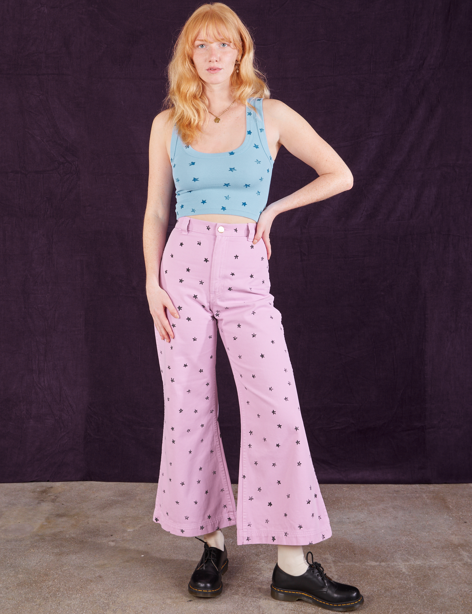 Margaret is wearing Star Bell Bottoms in Lilac Purple paired with Star Cropped Tank in blue