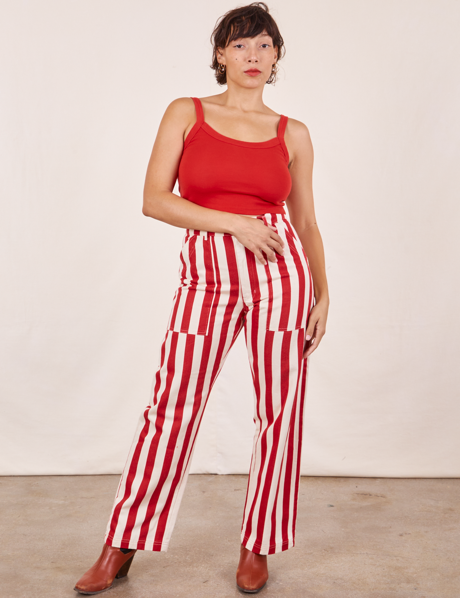 Tiara is 5&#39;4&quot; and wearing S Work Pants in Cherry Stripe paired with mustang red Cropped Cami