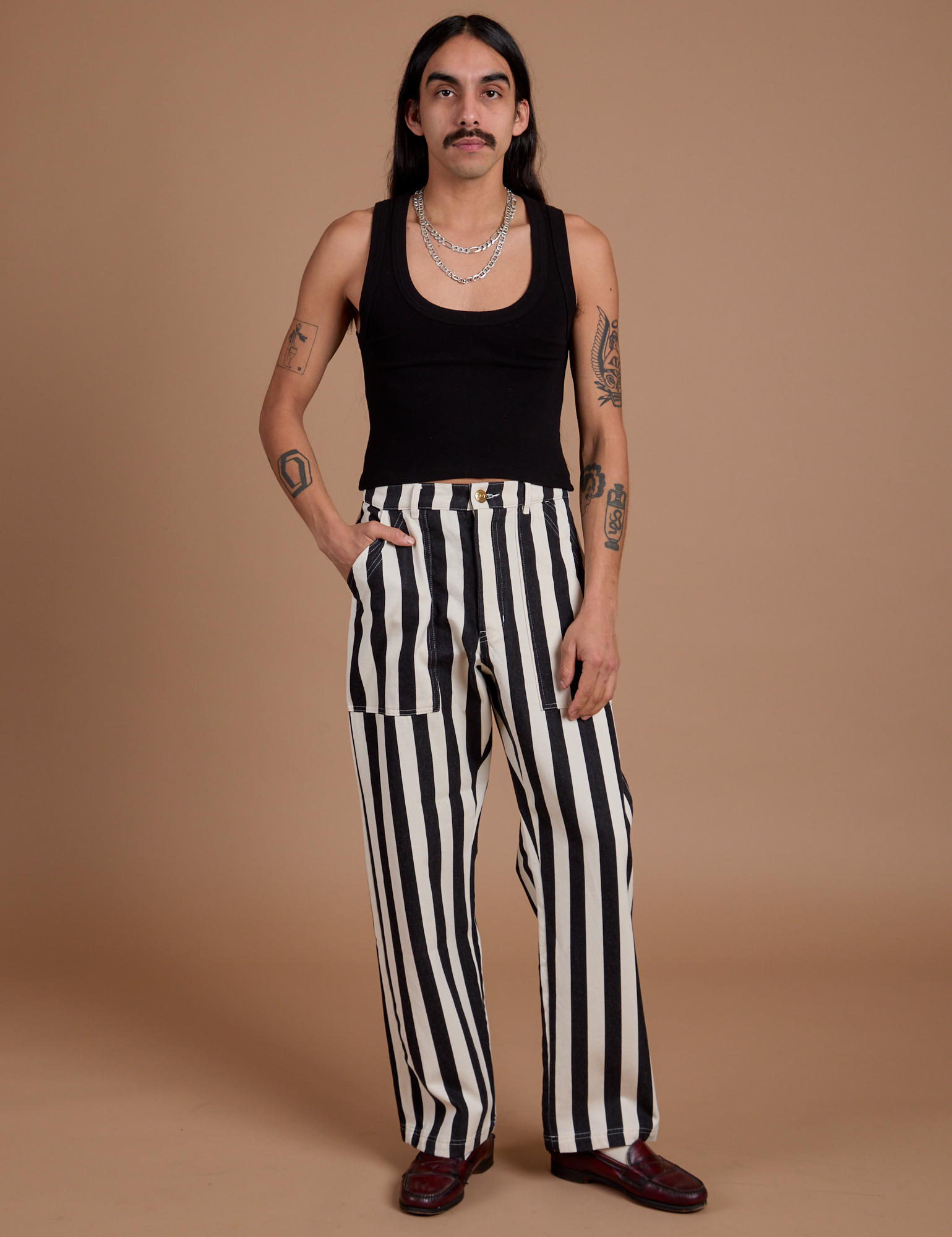 Anthony is 5’6” and wearing S Black Stripe Work Pants in White paired with black Cropped Tank