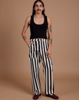 Anthony is 5’6” and wearing S Black Stripe Work Pants in White paired with black Cropped Tank