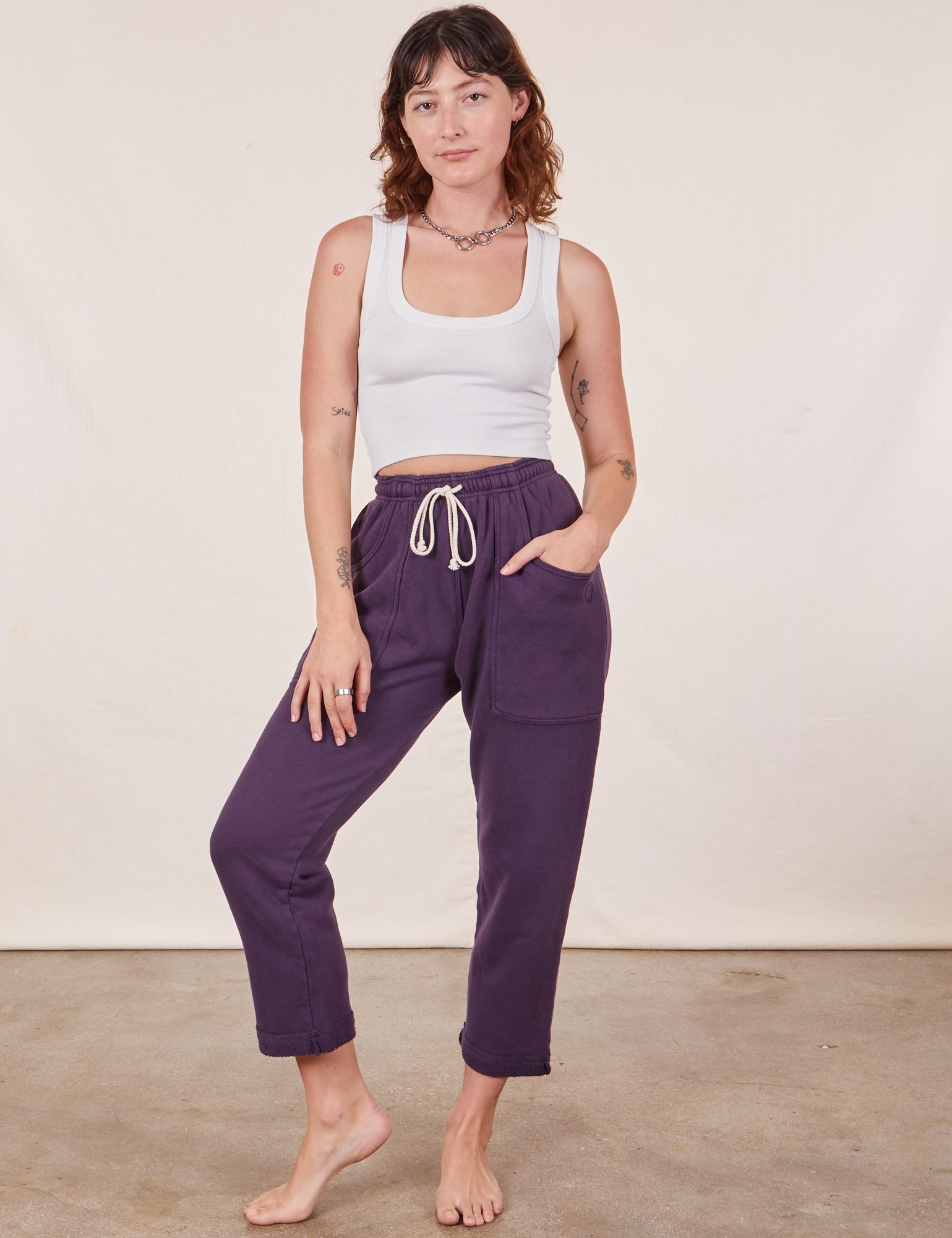 Alex is 5&#39;8&quot; and wearing XXS Cropped Rolled Cuff Sweatpants in Nebula Purple paired with vintage off-white Cropped Tank Top