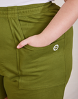 Lightweight Sweat Shorts in Summer Olive front pocket close up. Marielena has her hand int the pocket.
