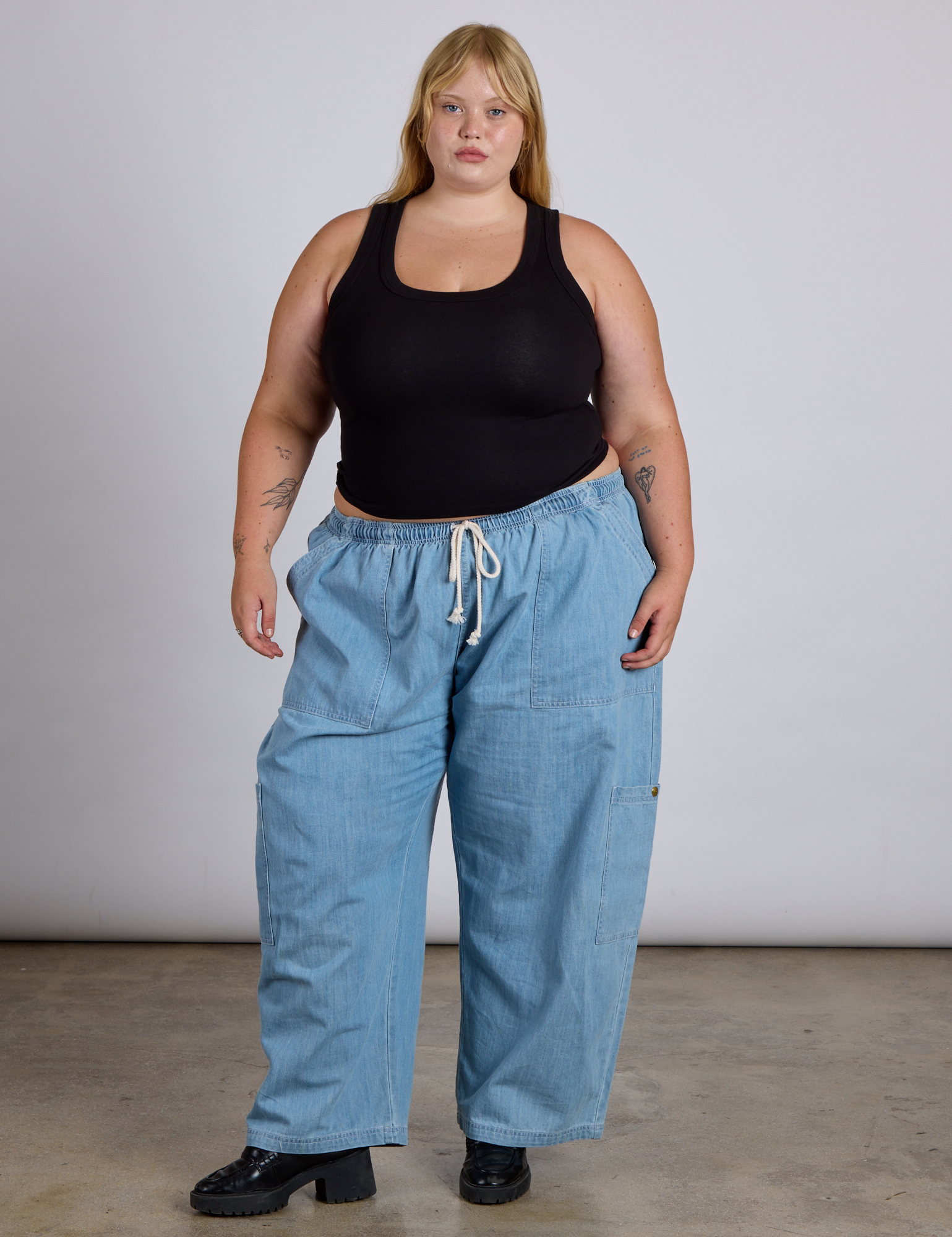Juliet is wearing The Tank Top in Basic Black paired with light wash denim drop pocket pants