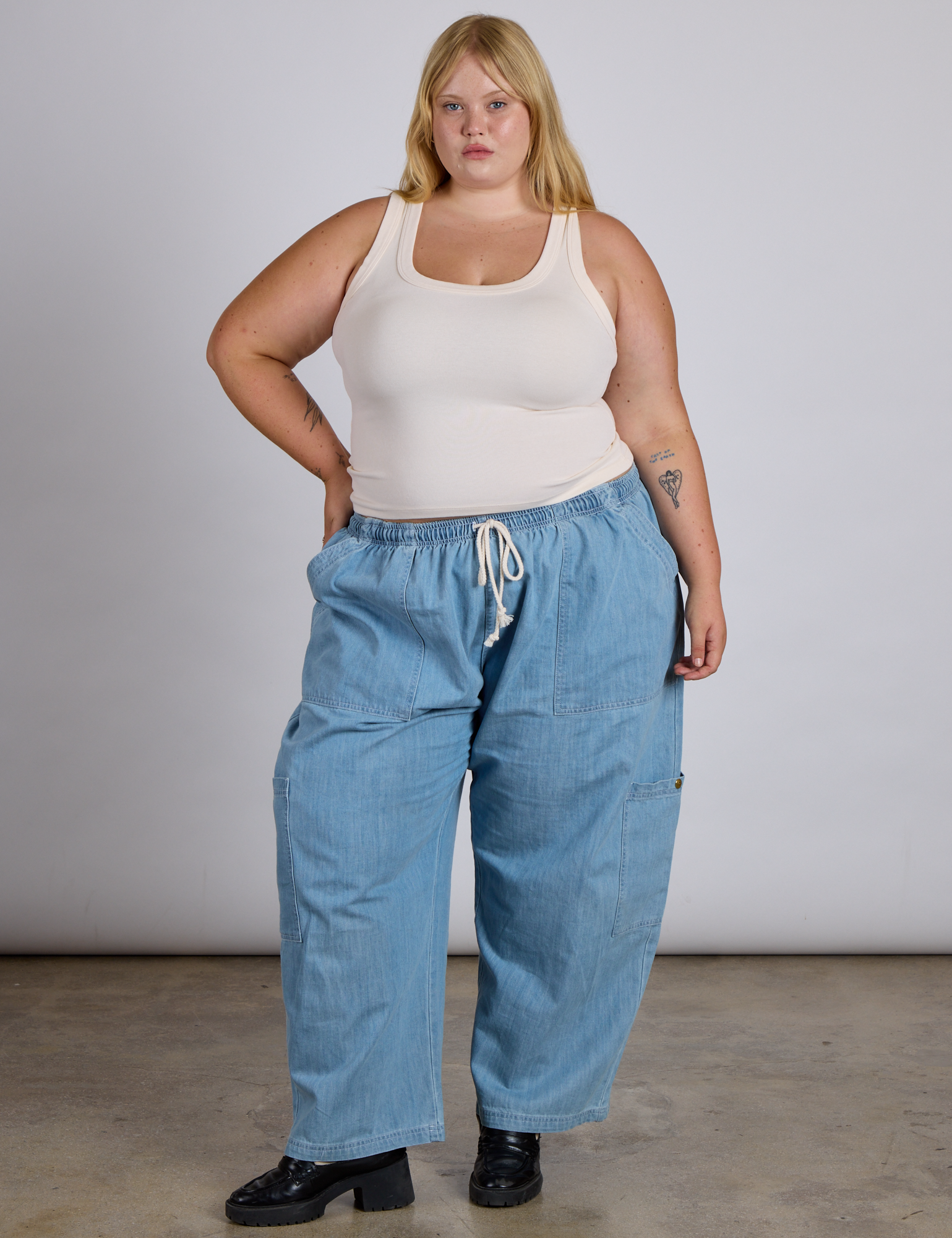 Juliet is wearing The Tank Top in Vintage Tee Off-White and light wash denim drop pocket pants