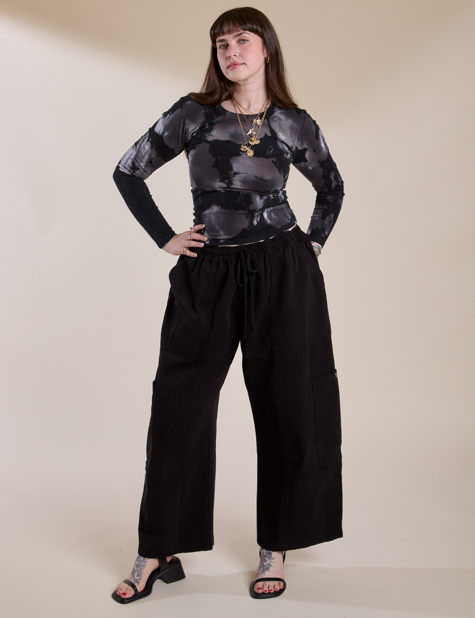 Sydney is 5'9" and wearing XXS Long Sleeve Baby Tee in Ink Blot paired with black Drop Pocket Cargo Pants