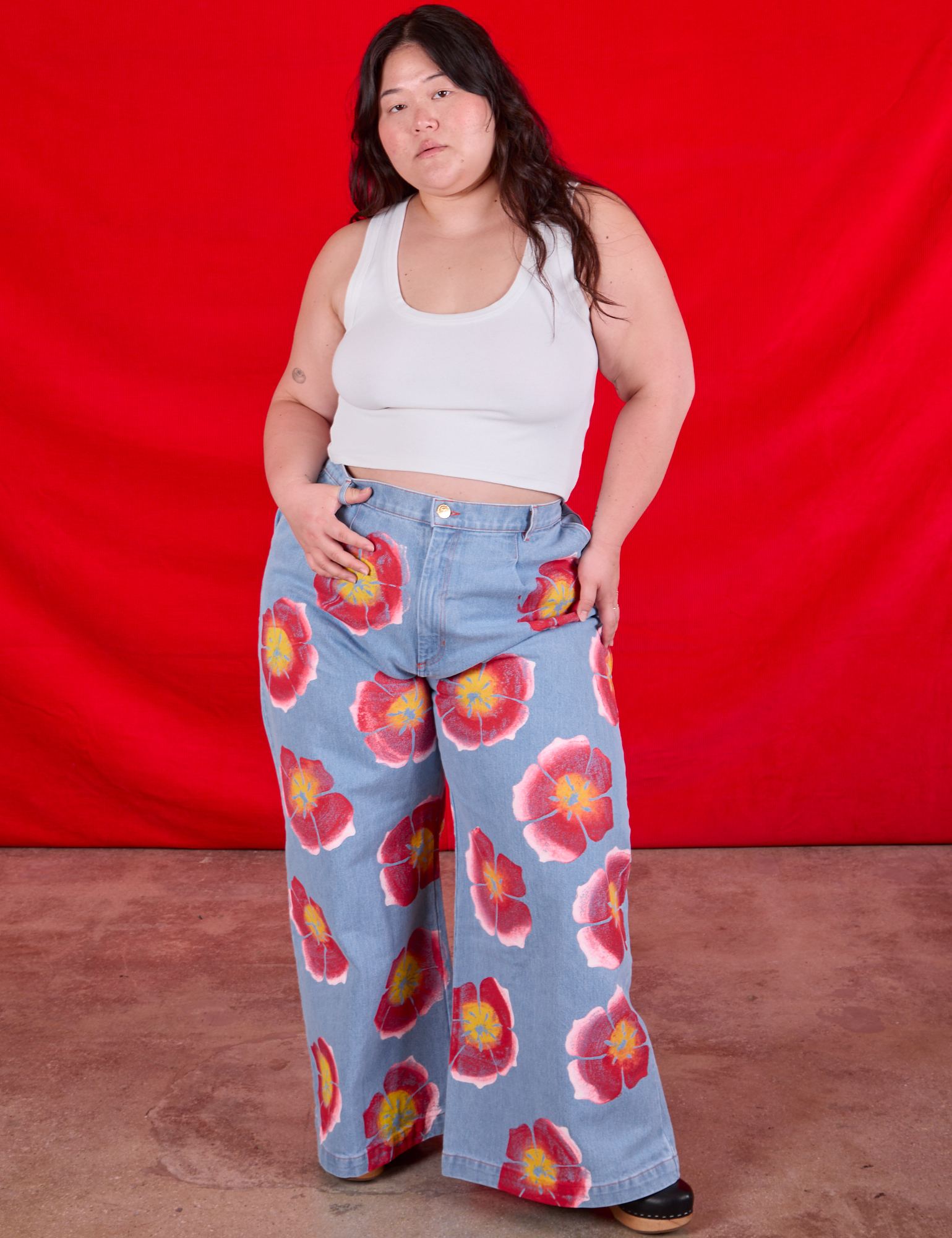 Ashley is 5&#39;7&quot; and wearing 1XL Wide Leg Denim Trousers in Painted Flowers paired with a Cropped Tank in Vintage Tee Off-White