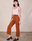 Side view of Western Pants in Burnt Terracotta and Cropped Tank in Vintage Tee Off-White worn by Alex