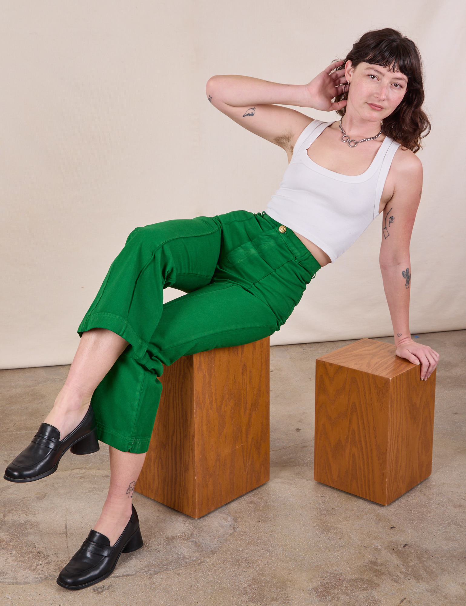 Alex is wearing Western Pants in Forest Green and Cropped Tank in Vintage Tee Off-White