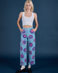 Madeline is 5’9” and wearing XXS Floral Painted Work Pants in Blue paired with a Cropped Tank in Vintage Tee White