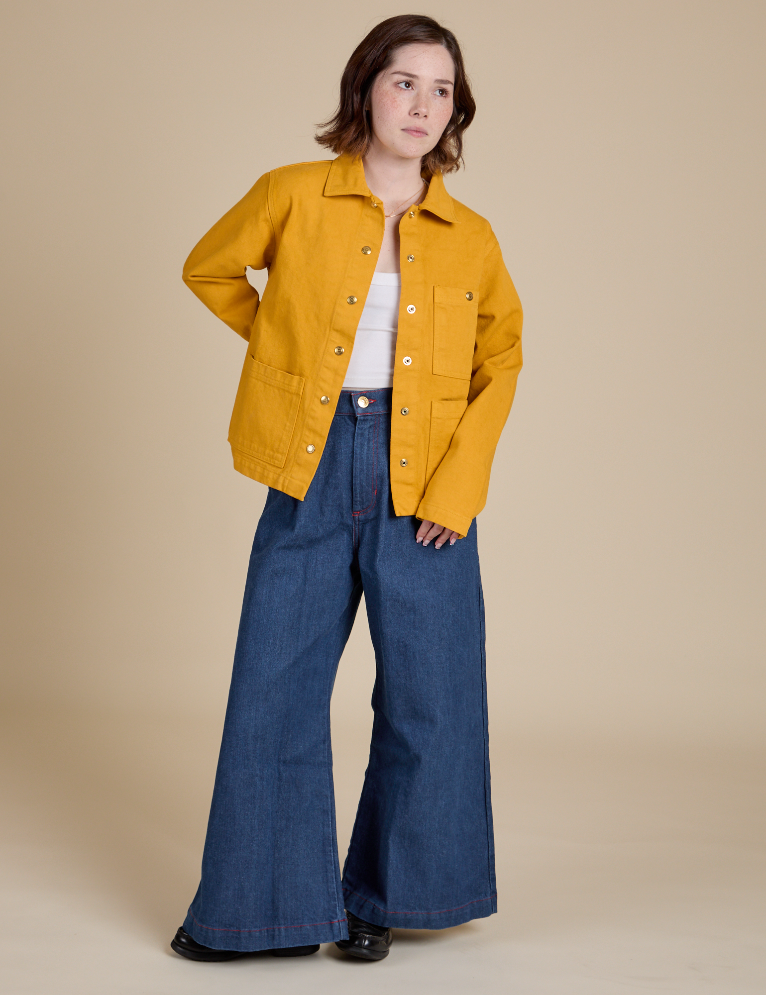 Hana is wearing Denim Work Jacket in Mustard Yellow and dark wash Indigo Wide Leg Trousers