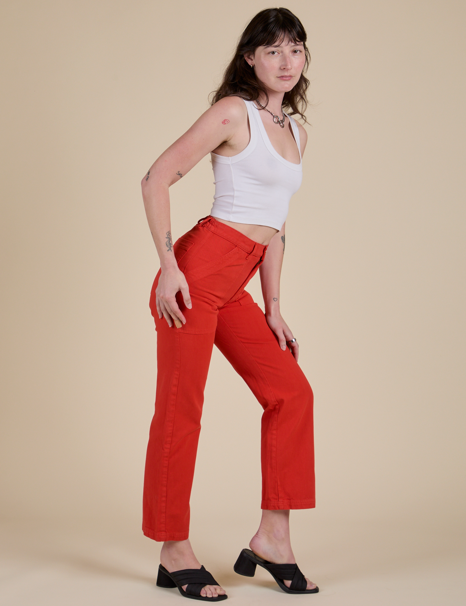 Side view of Work Pants in Mustang Red and Cropped Tank in Vintage Tee White on Alex