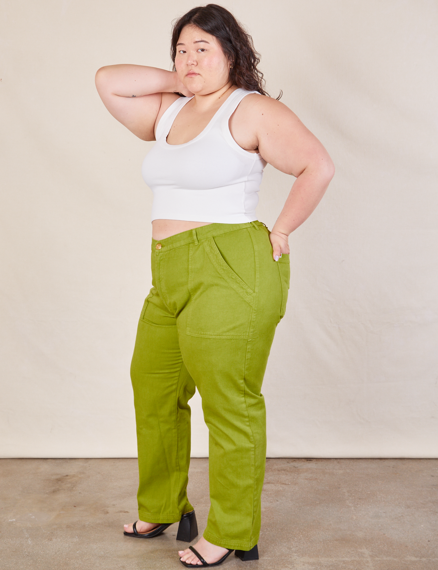 Angled front view of Work Pants in Gross Green and Cropped Tank in vintage tee off-white on Ashley