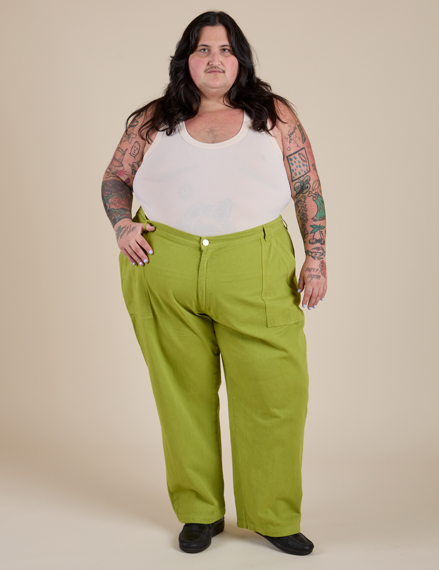 Sam is 5’10” and wearing 4XL Work Pants in Gross Green paired with a vintage tee white Cropped Tank