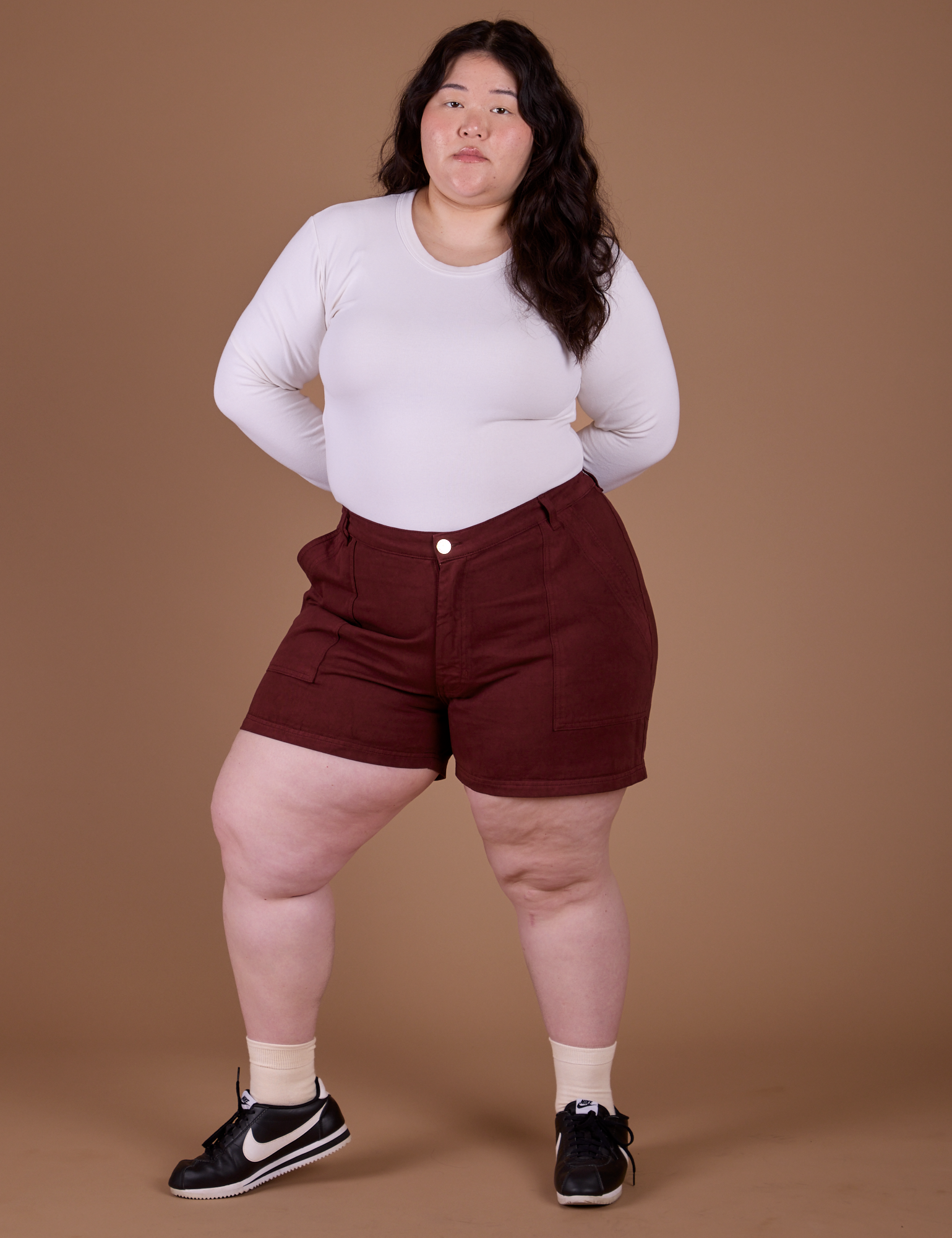 Ashley is 5’7” and wearing 1XL Classic Work Shorts in Red Wine paired with vintage tee white Long Sleeve Baby Tee