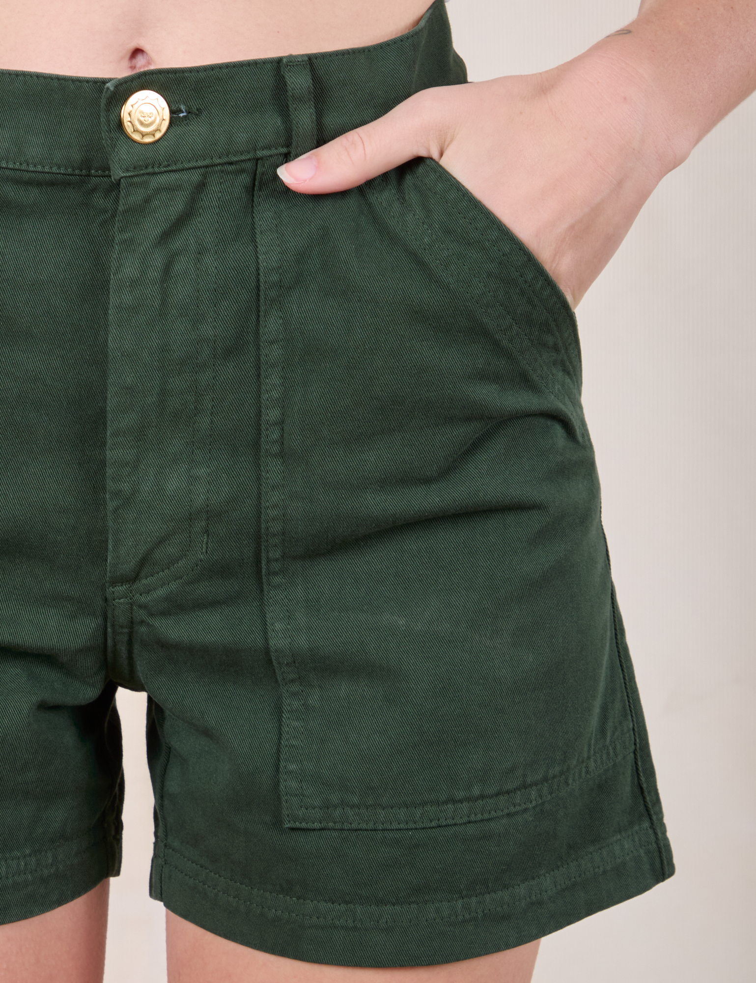 Close up of Alex&#39;s hand in the front pocket of Classic Work Shorts in Swamp Green