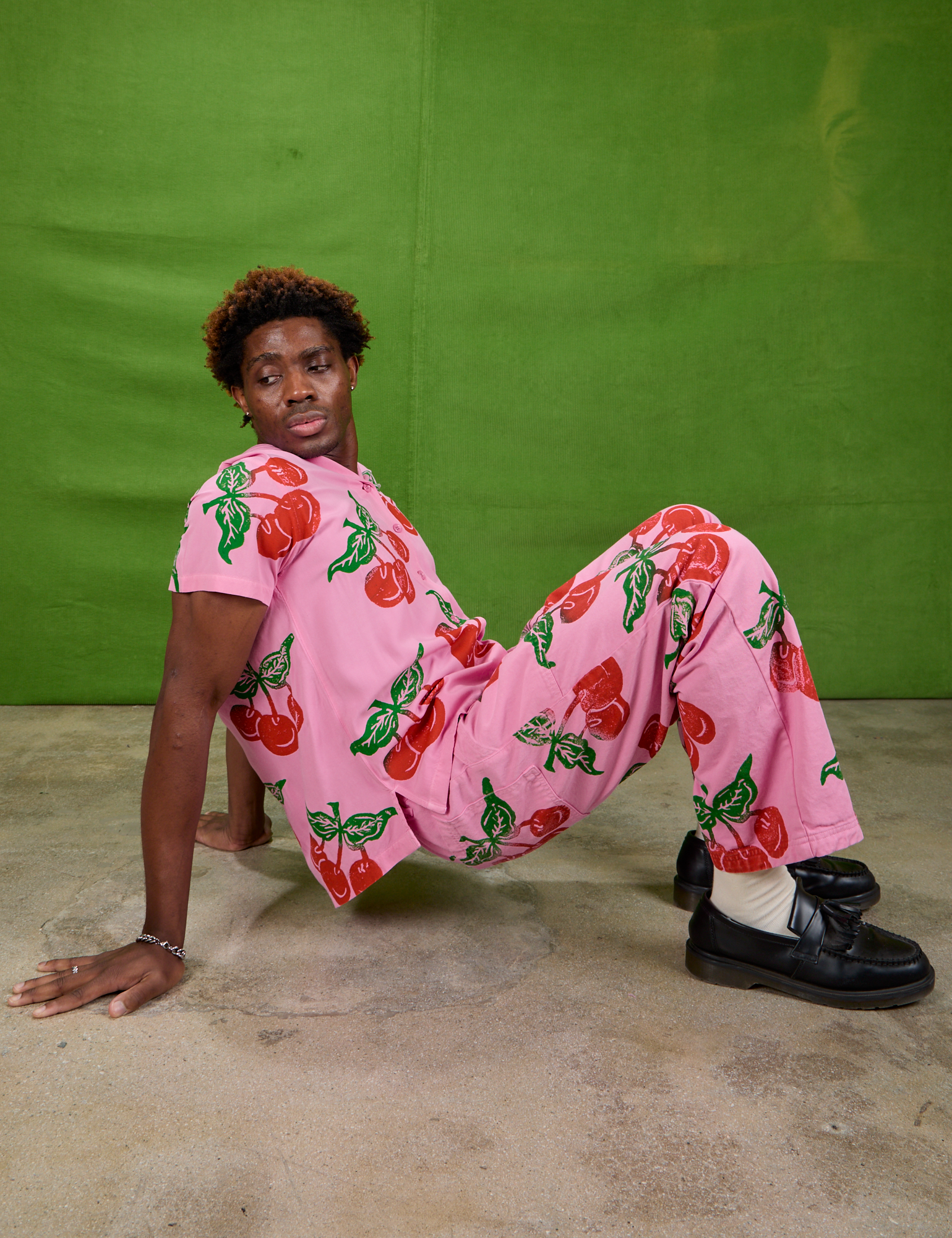 Isaac is wearing Cherry Pantry Button-Up and matching Work Pants