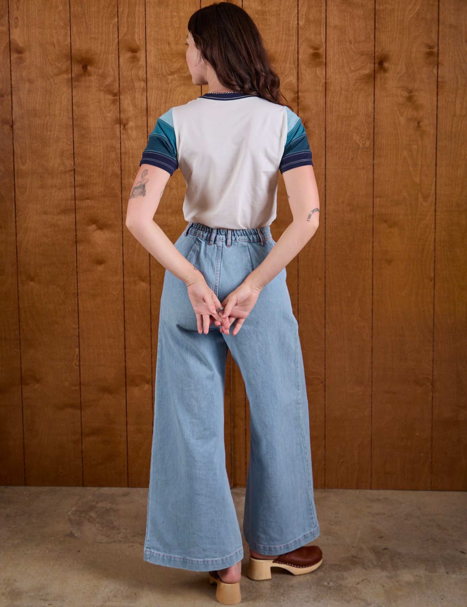 Back view of Calypso Tee in Ocean and light wash Indigo Wide Leg Trousers on Alex