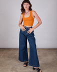 Alex is wearing Cropped Tank Top in Creamsicle Orange paired with dark wash Indigo Wide Leg Trousers