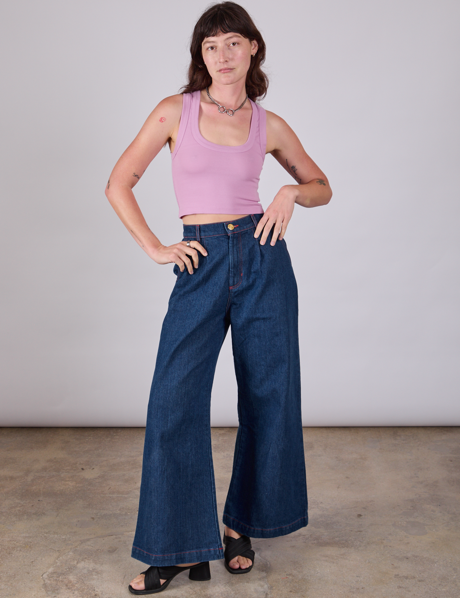 Alex is wearing Cropped Tank Top in Lilac paired with dark wash Indigo Wide Leg Trousers