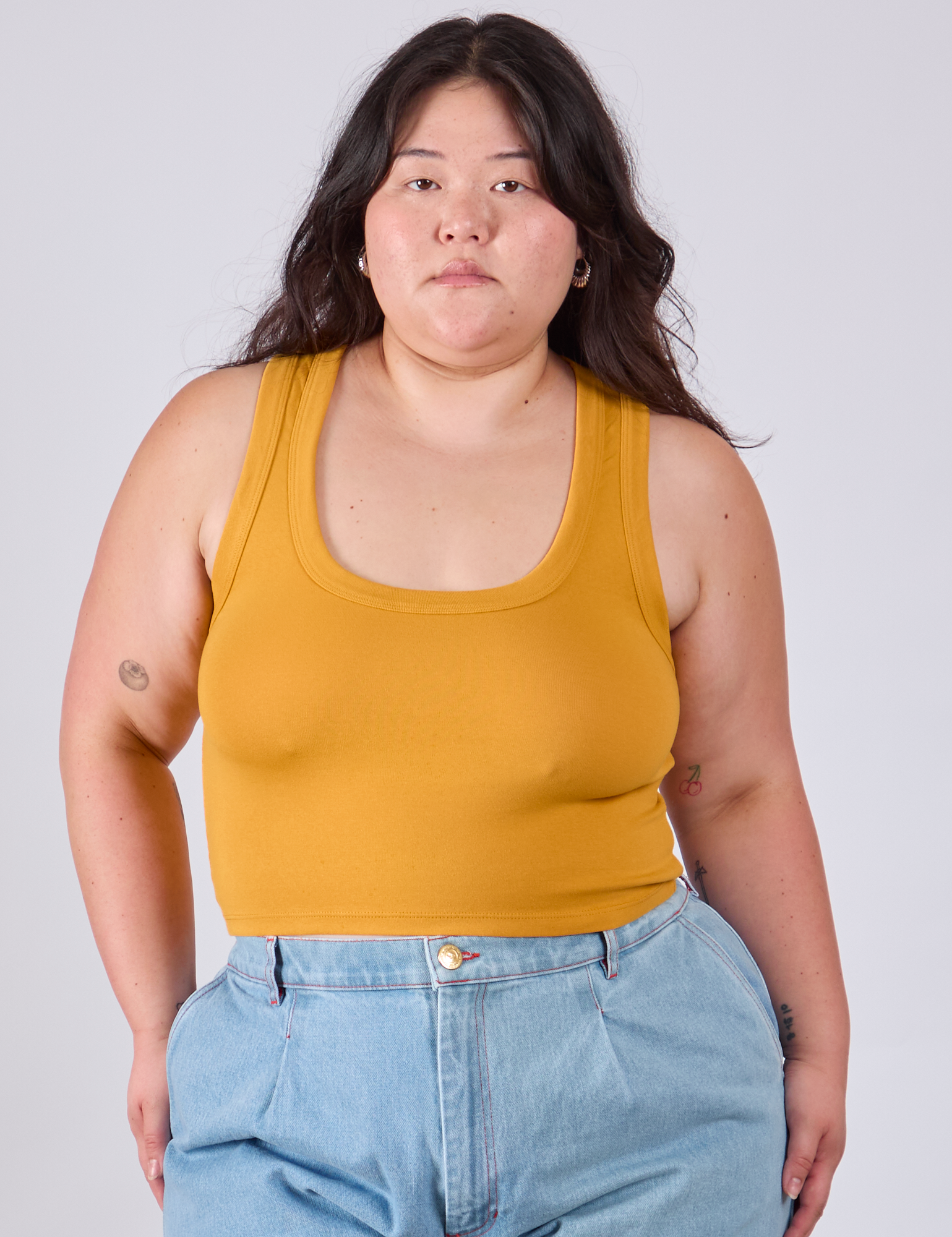 Ashley is 5&#39;7&quot; and wearing L Cropped Tank Top in Mustard Yellow