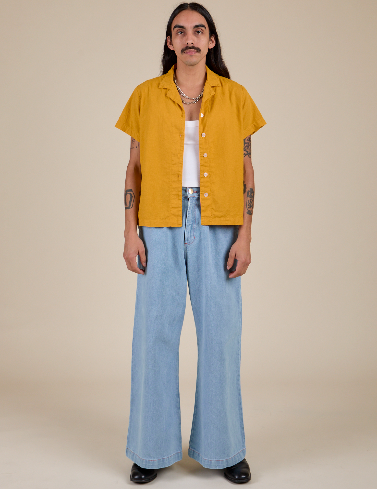 Anthony is wearing Pantry Button-Up in Mustard Yellow and light wash Indigo Wide Leg Trousers