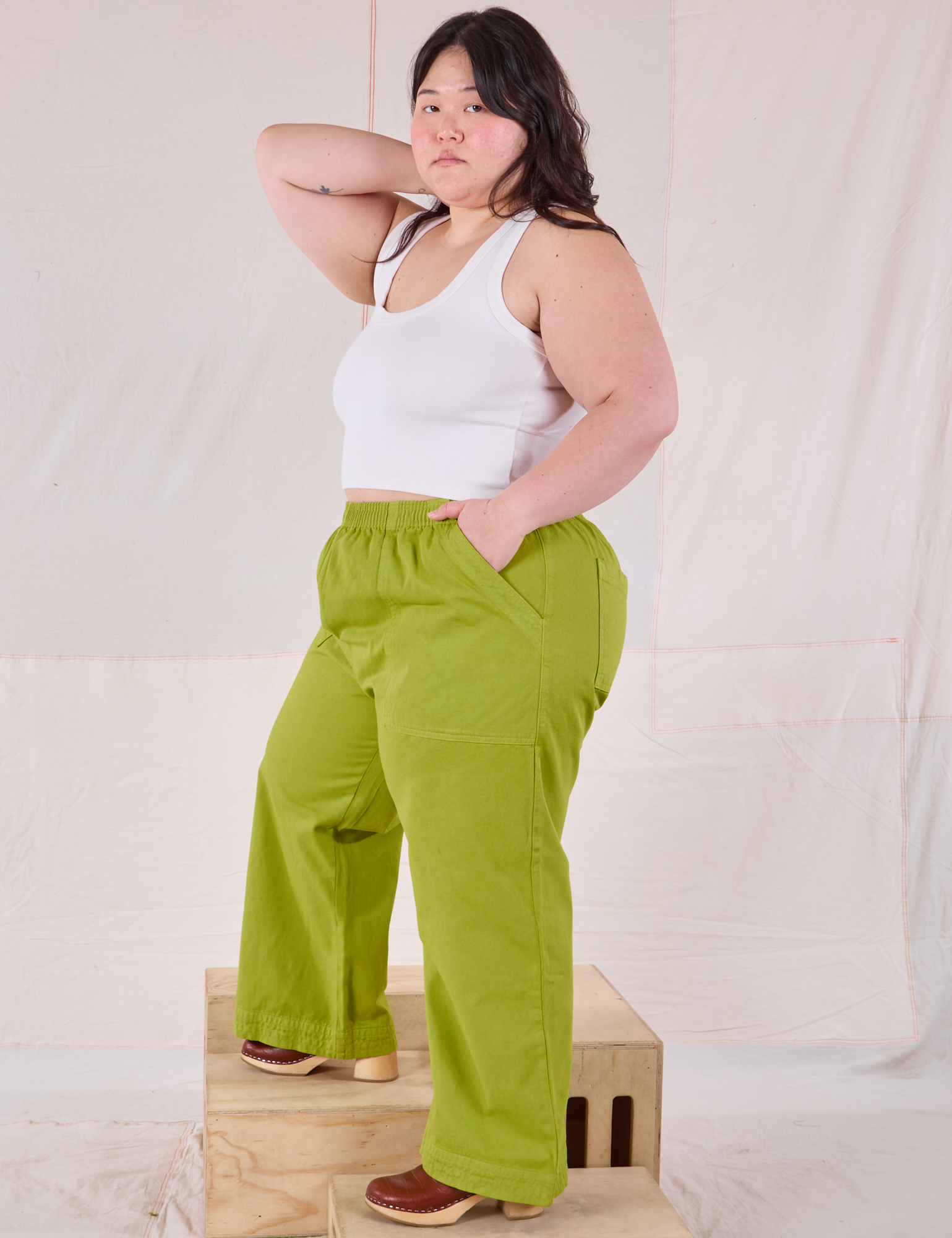 Side view of Action Pants in Gross Green and Cropped Tank in Vintage Tee Off-White on Ashley