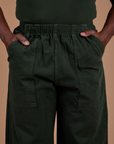 Action Pants in Swamp Green front close up with Demi's hands in both front pockets