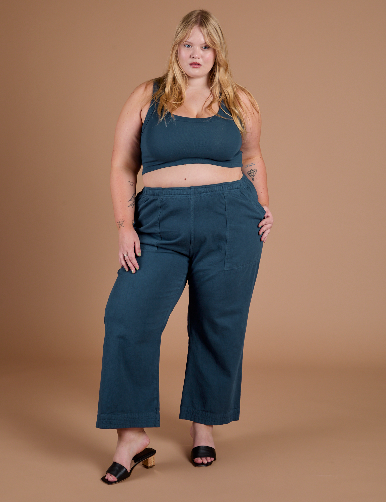 Juliet is 5’7” and wearing 1XL Action Pants in Lagoon paired with lagoon Mini Tank