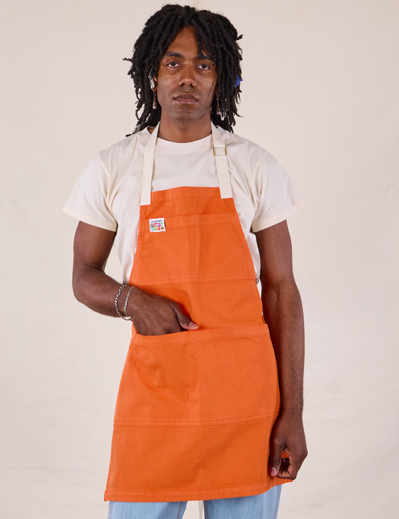 Jerrod is wearing the Full Denim Apron in Construction Orange