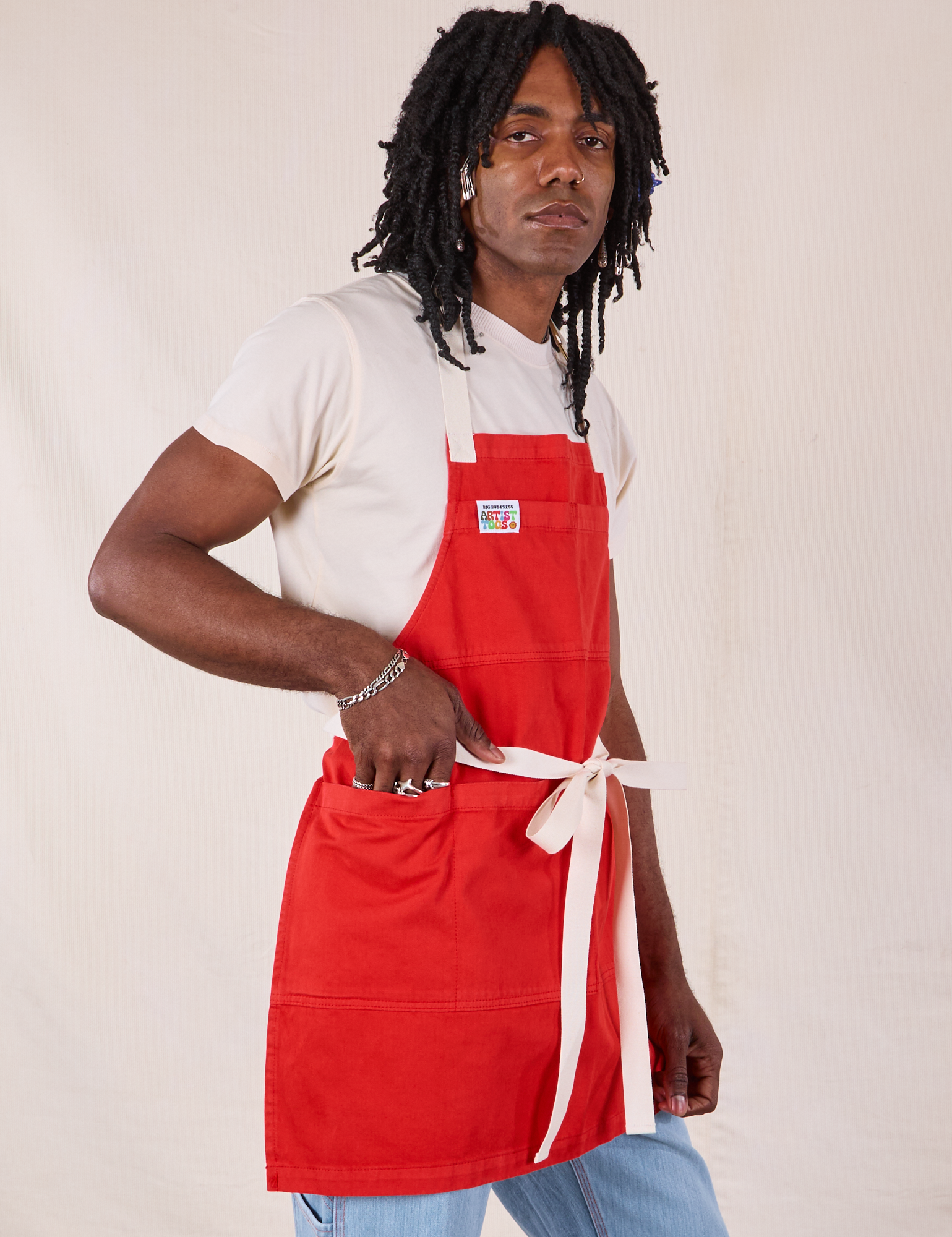 Angled view of Full Denim Apron in Mustang Red on Jerrod