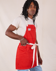 Angled view of Full Denim Apron in Mustang Red on Jerrod