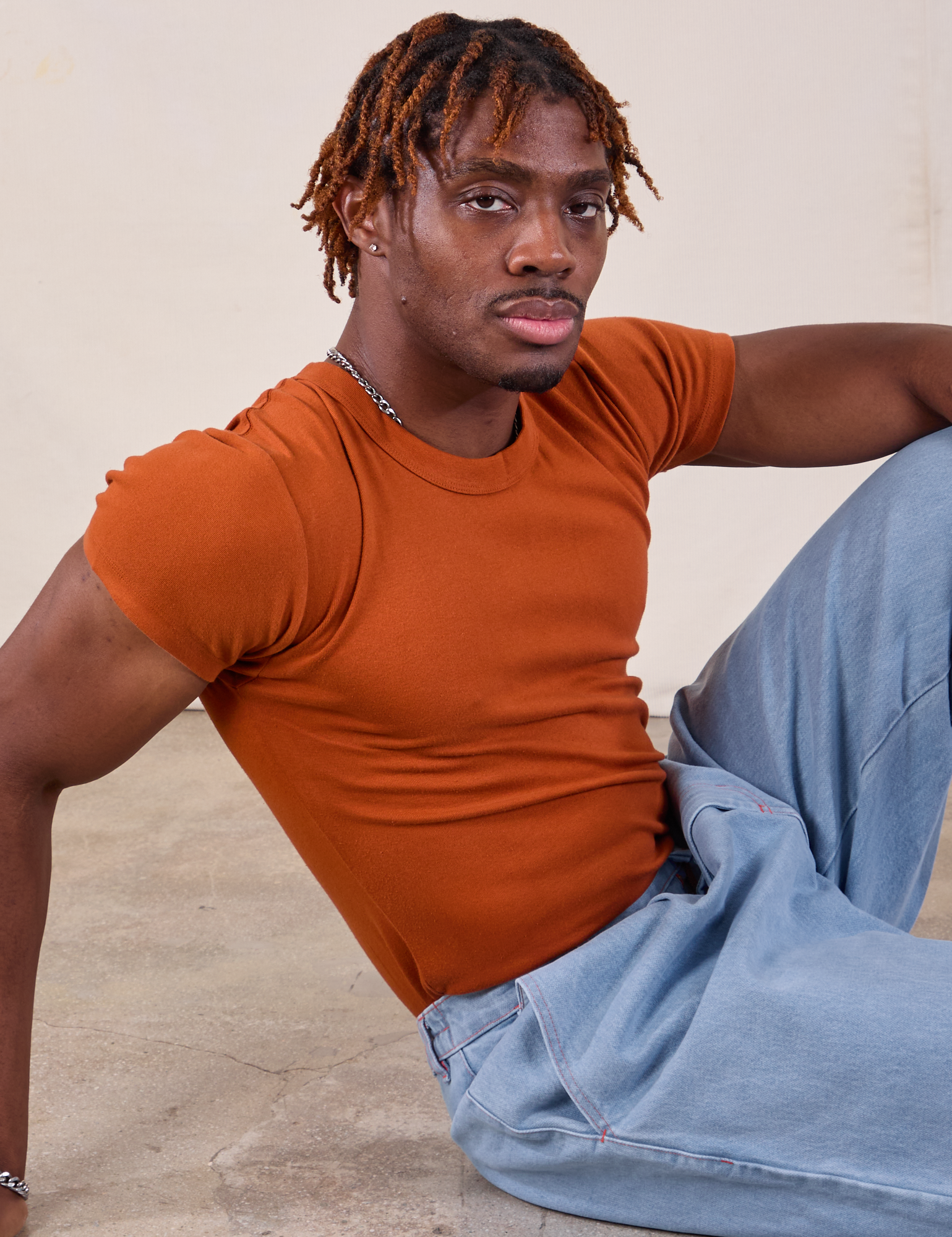 Isaac is wearing Baby Tee in Burnt Terracotta