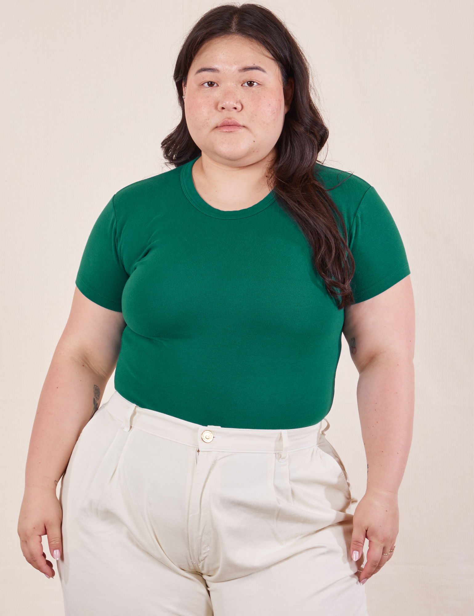 Ashley is wearing Baby Tee in Hunter Green tucked into vintage off-white Heavy Weight Trousers