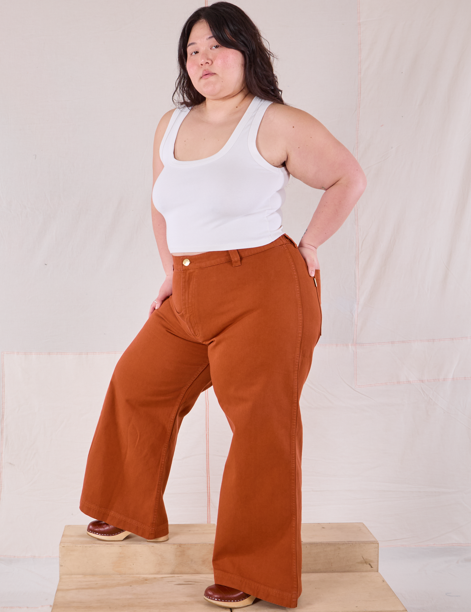 Angled front view of Bell Bottoms in Burnt Terracotta and Cropped Tank in vintage tee off-white on Ashley