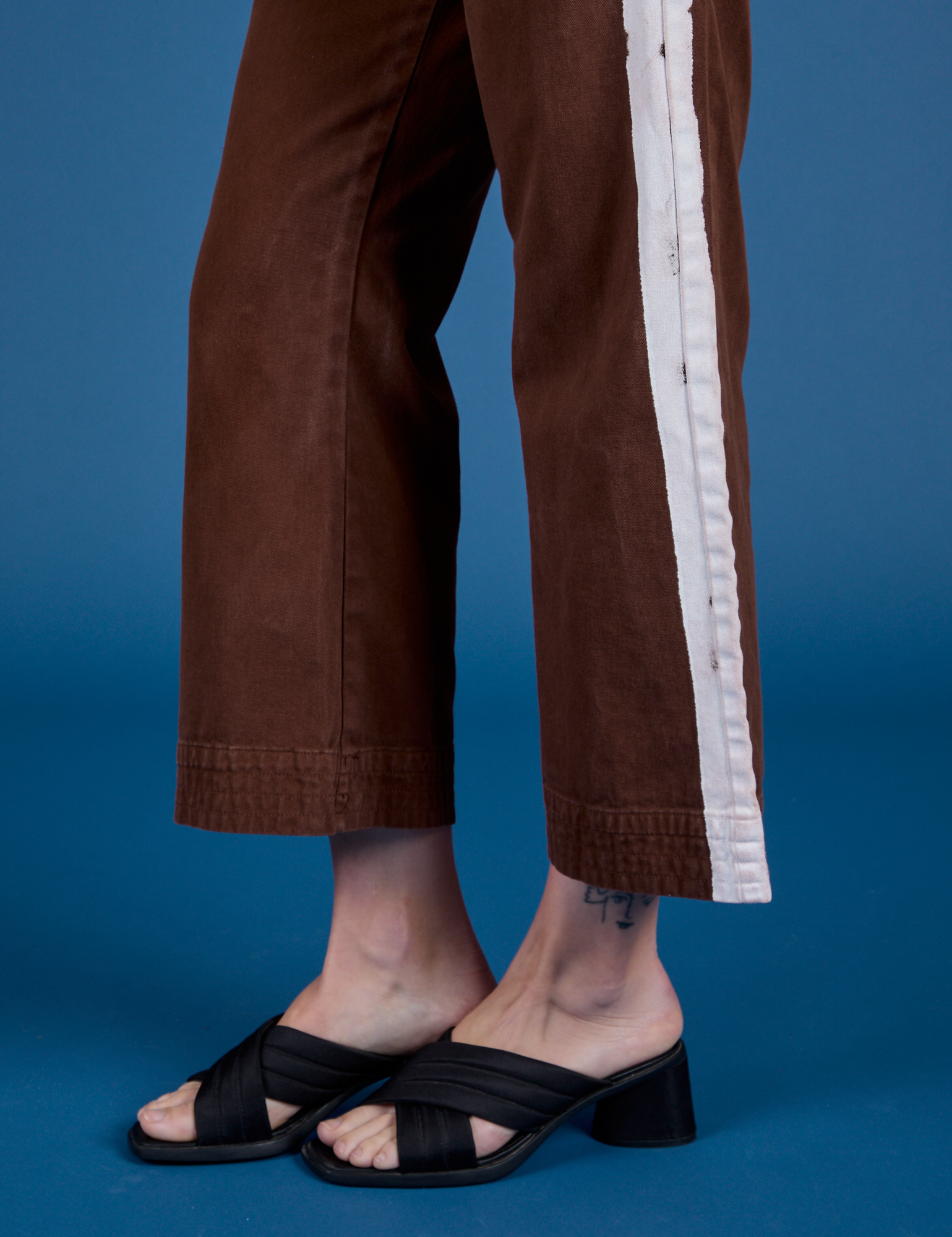 Painted Action Pants in Fudgesicle Brown pant leg close up on Alex