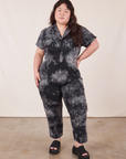 Ashley is 5'7" and wearing 1XL Petite Short Sleeve Jumpsuit in Black Magic Waters