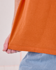 Burly Tee in Construction Orange bottom hem close up on Quinn