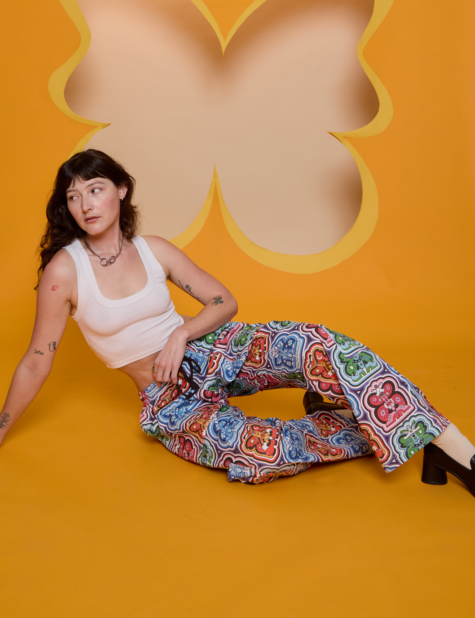 Alex is wearing Butterfly Kaleidoscope Drop Pocket Cargo Pants and vintage tee white Cropped Tank