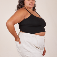 Side view of Cropped Cami in Basic Black and vintage off-white Western Pants worn by Alicia