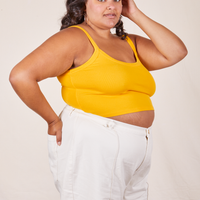 Angled view of Cropped Cami in Sunshine Yellow and vintage off-white Western Pants worn by Alicia