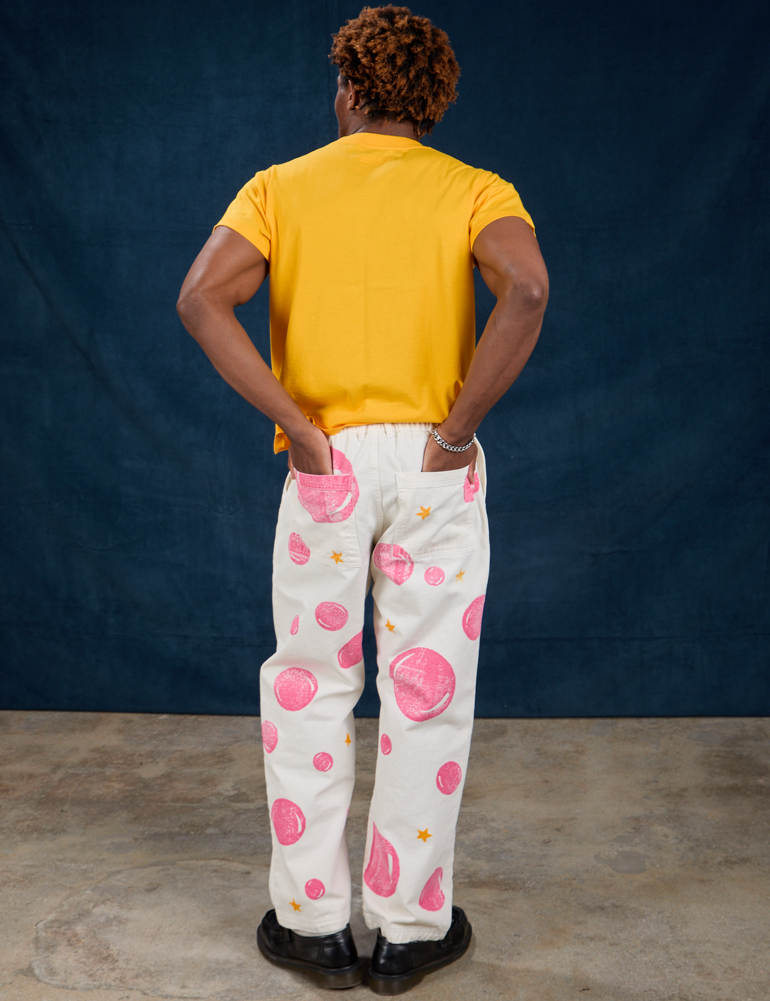 Back view of Paintstamped Work Pants in Bubblegum and sunshine yellow Organic Vintage Tee