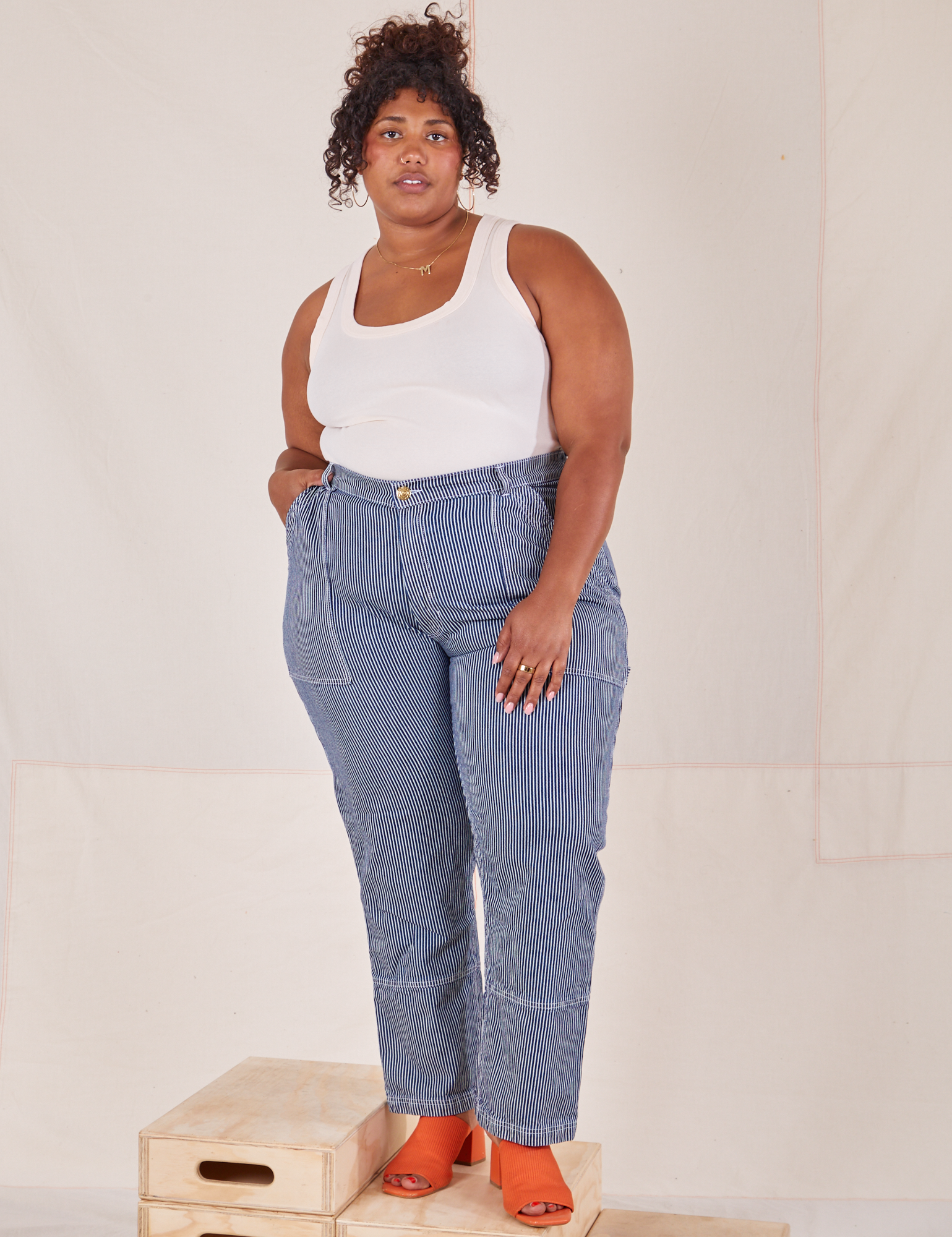 Morgan is 5&#39;5&quot; and wearing 1XL Carpenter Jeans in Railroad Stripes paired with vintage off-white Tank Top